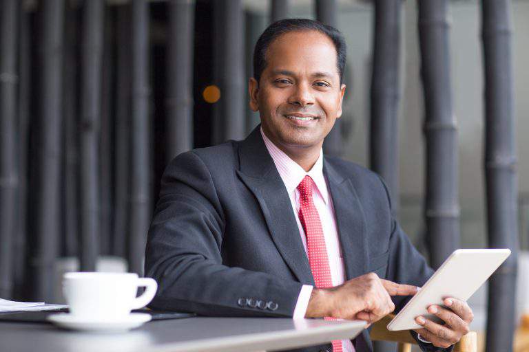 Happy Business Leader Working on Tablet in Cafe
